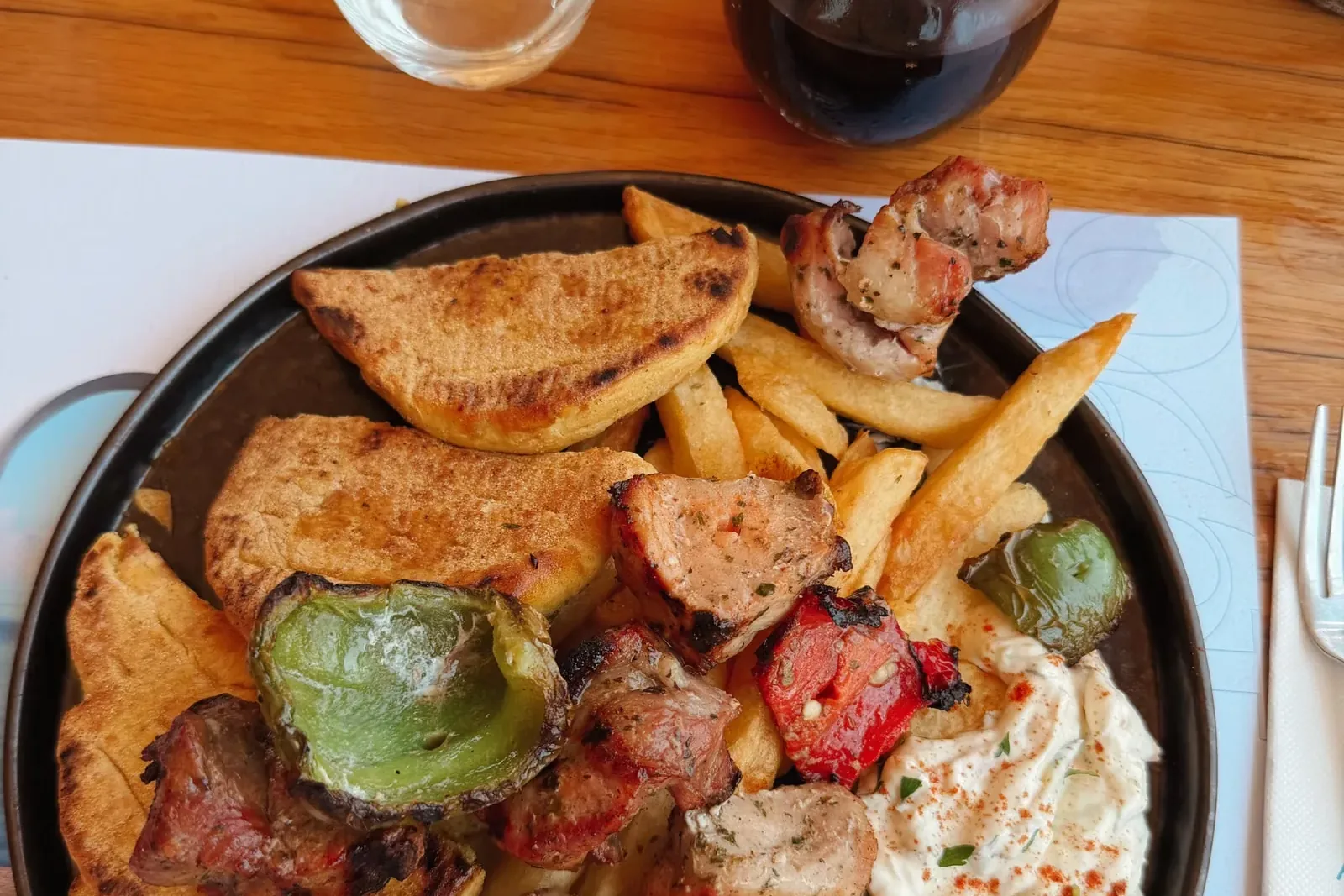 Grillteller mit Souvlaki, Pita, Pommes und Tzatziki (Symbolbild)