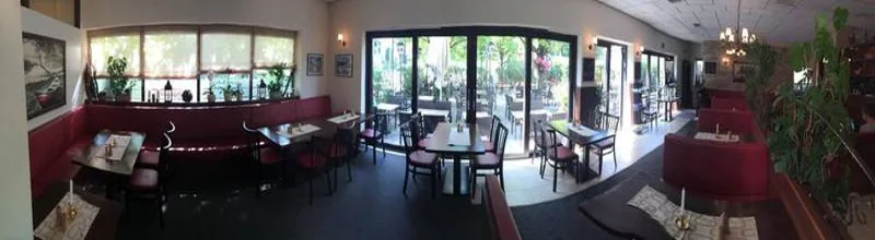 Gastraum mit roten Bänken und Glastüren zur Terrasse, breite Ansicht